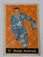 Front view of vintage George Armstrong hockey card with orange patterned background and player in blue Toronto Maple Leafs uniform with captain's C and number 17.