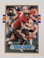 Front side of Steve Young football card showing him in 49ers uniform with football, with Topps logo.