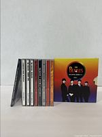 Collection of 9 CDs including Beatles box set and John Lennon albums presented in a line