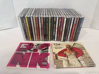 Photograph showing 28 music CDs in jewel cases with two Pink albums displayed in front.