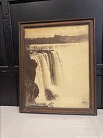 Front view of the framed antique Niagara Falls print, showing the waterfall and distant buildings in sepia tone.