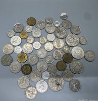 Coins spread out on a flat surface showing various sizes, designs, and metals under clear lighting.