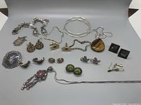 Overview of entire lot showing bracelets, necklaces, earrings, cufflinks, brooches and pendants