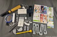 Full lot arranged showing games, accessories, controllers, balance board, and attachments.