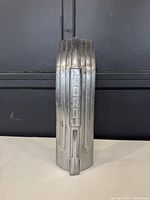 Front view of the 1941 Ford hood ornament showing the vertical 'FORD' inscription and overall shape.