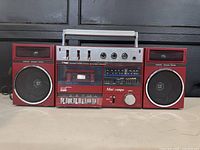 Front view of vintage Prosonic Mini Compo cassette portable stereo system with cassette tape in deck, control knobs, and detachable speakers visible.