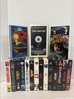 Full view of all 17 VHS horror tapes showing front covers, arranged in two rows against a plain background.