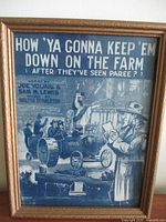 Framed sheet music showing title and vintage illustration on the cover with people, car, and a man reading a newspaper.