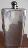 Front view of the large silverplate flask showing rectangular shape and cap