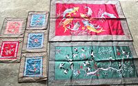 Overview of all seven silk embroidered tapestries with koi fish, cranes, birds, and floral designs laid out flat.