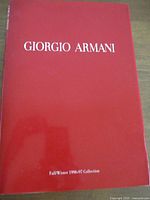 Front cover of the Giorgio Armani Fall/Winter 1996-97 look book showing bright red matte finish with white text.