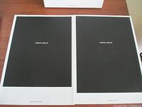 Two Giorgio Armani black matte cover look books, one slightly larger and both with white outer sleeves showing minor wear and markings