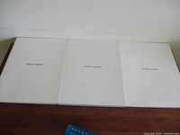 Front covers of three white Giorgio Armani look books with clean, minimalist branding in black text.