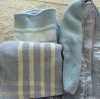 Folded view of three blue blankets showing color and patterns