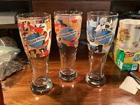 Front view of three Belgian Moon 8" pilsner beer glasses with colourful wrap designs