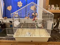 Full view of white Hagen bird cage on counter