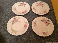 Four Royal Doulton Arcadia bread plates front view showing floral pattern and scalloped edges