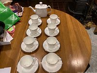 Top view of Royal Doulton Platinum Concord teapot, eight cups and eight saucers arranged on table
