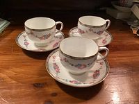 Three Paragon teacups on matching saucers showing floral pattern and gold trim