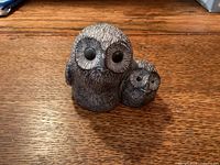 Front view of two-owl figurine showing eyes and feather details