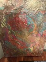 Close-up showing details of the painting's texture and vibrant color swirls with metallic highlights.