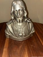 Front view of antique silver-tone Jesus bust statue showing detailed facial features and sacred heart symbol.