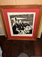 Full view of framed 'Winter Mountains' linocut print by May Leung, showing oak frame and red matte.