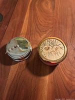 Pair of vintage Japanese Chokin trinket boxes on wooden surface, showing the gold inlay floral box and silver-tone box with beaded chain