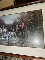 Framed hunting scene print showing riders on horseback with dogs in woodland setting, labelled as 'The Hunt' by Heywood Hardy.