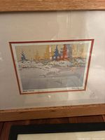 Framed artwork titled "Bright Passage" showing a winter landscape with snow and colorful trees, signed by Robert Genn.