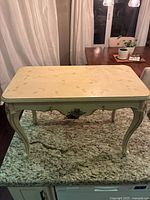 Front view of vintage Pulaski console table showing handpainted floral top and ornate carved legs.