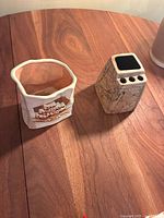 Both pottery candleholders viewed from above on a wooden table, showing general size and shapes.