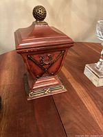 Wood trophy, reddish with brass golf ball and crossed clubs emblem on front