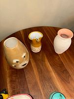 Top angled view showing all three vases on wooden surface, highlighting colors and shapes.