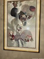 Full frontal view of the framed painting showing all seven clown faces and signature.