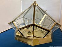 Hexagonal brass and glass ceiling light fixture showing geometric shape, glass panels with brass framing, and polished brass base.