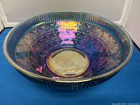 Top angled view of blue carnival glass bowl showing iridescent finish and cut glass pattern.