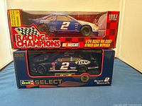 Two boxed NASCAR diecast stock car replicas featuring Rusty Wallace in sealed packaging, one Racing Champions and one Revell Select from 1997.