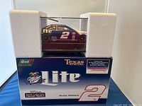 Side view of diecast NASCAR model car and original box with foam packaging.