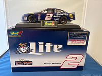 Photos of the Revell 1:24 Miller Lite Car #2 diecast model on its original branded display box, clear views of front and side profiles.