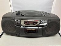 Full front view of Sharp QT-CD77 boombox showing speakers, control panel, and top controls including CD player lid.