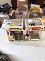 Two original boxed Funko Pop! figures of Fred Flintstone (#119) and Barney Rubble (#120) placed side by side on a white surface.