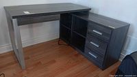 Full view of L-shaped desk showing left leg section and right side with drawers and shelves
