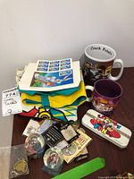 Full view of mixed Looney Tunes collectibles, including shirts, mugs, stamps, tin box, and the watch visible.