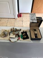 Lot display including the mixed jewelry set with earrings, bracelet, two beaded necklaces, pearl cluster brooch, and boxed Elgin wristwatch.