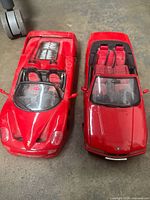 Both red convertible model cars side by side showing interior details and body condition.