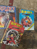 Three Rip Off Comix magazines laid out showing covers of issues 30, 20, and 23.