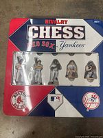 Top face of the game box showing Red Sox vs Yankees themed Rivalry Chess set with five custom chess pieces visible through window.