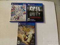 Three PS4 game cases laid out on a white surface: It Takes Two (sealed), Call of Duty Vanguard, Just Dance 2019.