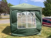 Canopy fully set up with one side showing two arched clear window panels.